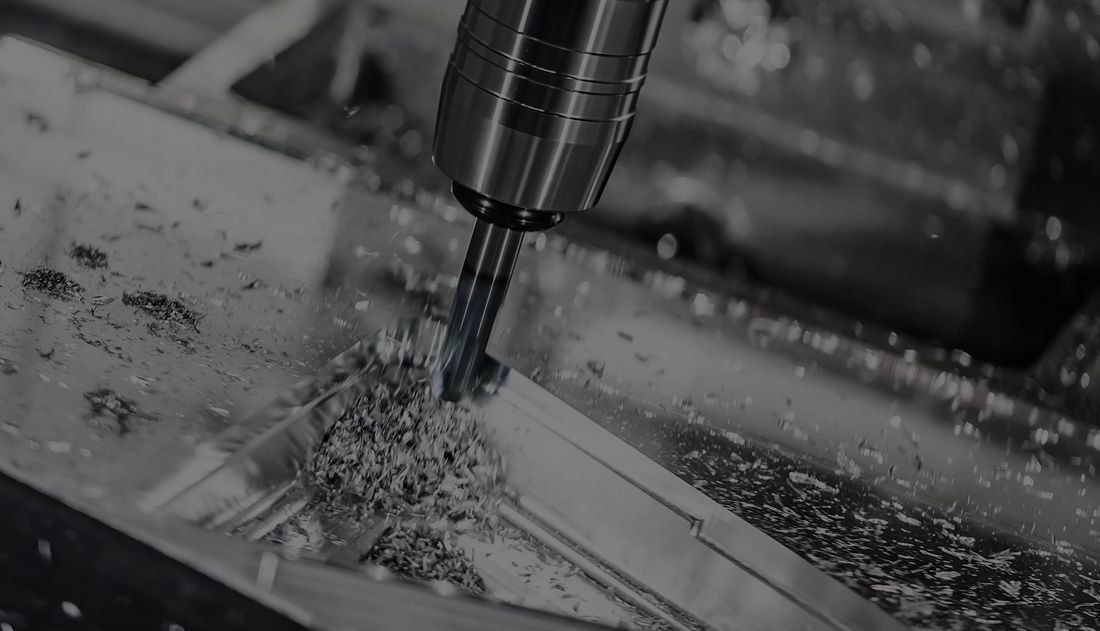 Close-up of a milling machine cutting metal, with metal shavings scattered around