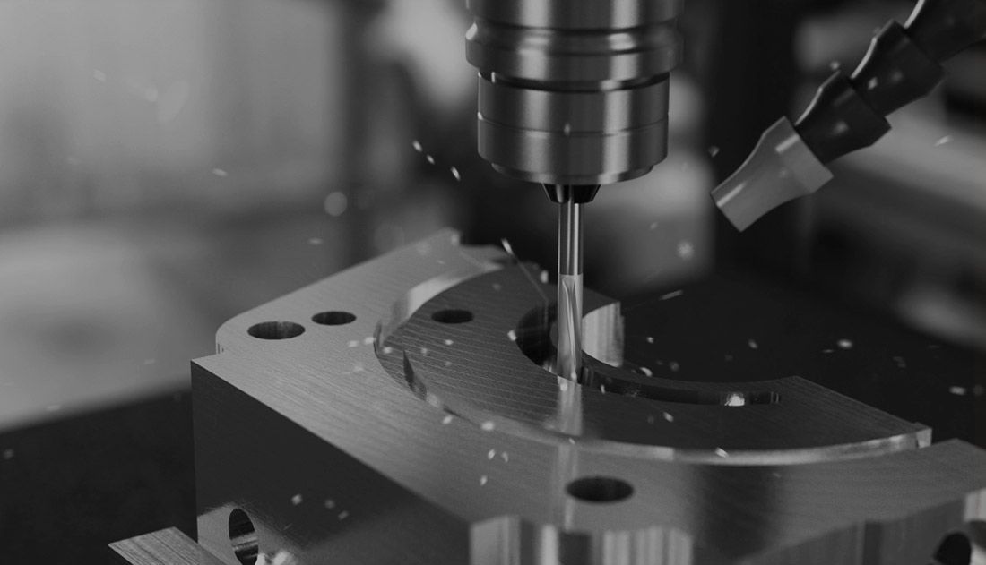 Milling tool machining a metal block with multiple holes, chips flying.