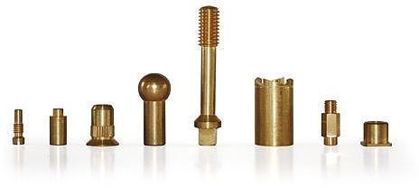 Eight different brass parts in various shapes and sizes, lined up in a row.